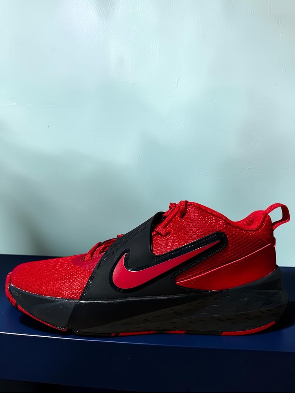 Nike Team Hustle D 12, styled in a striking University Red, Black, and Anthraci